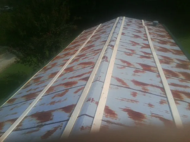 Rusted metal roof panels with new wood purlins before replacement — Storm Damage Roof Repair in Harris by Roofing Brothers