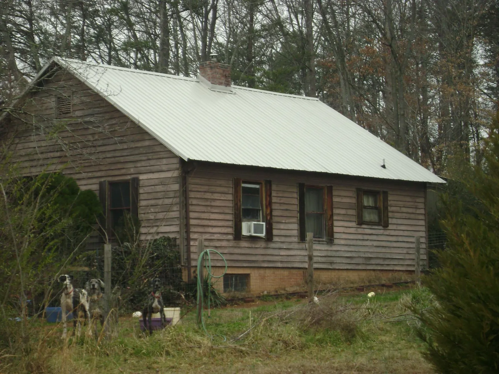 White metal roof on an old wood sided farmhouse, from a Metal Roof Installation job in Harris
